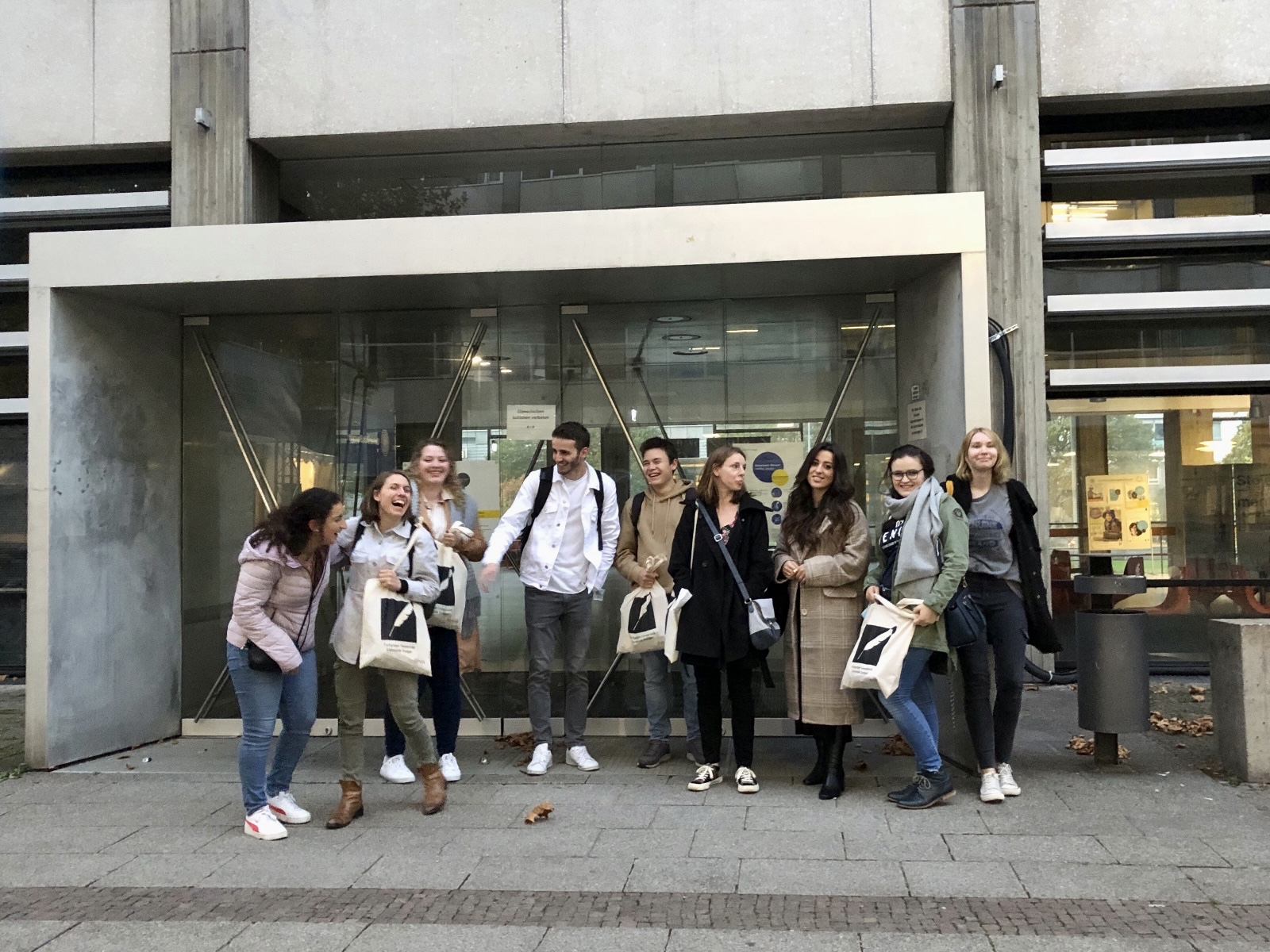Die Fachgruppe (2021) mit neuen Merch-Taschen vor dem K2.